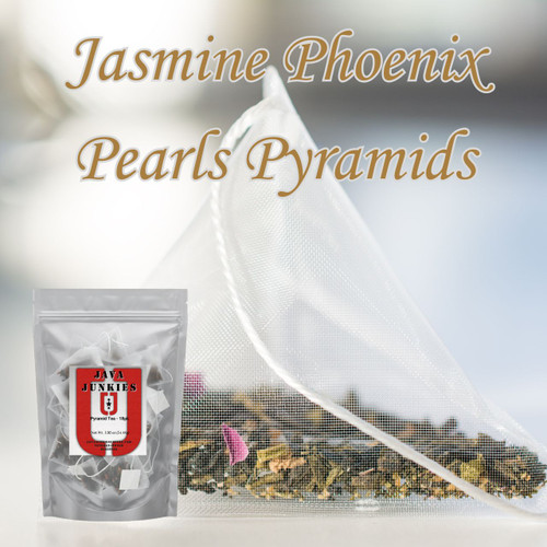 A close-up view of a mesh pyramid tea bag filled with dried green tea leaves and delicate floral petals, next to a retail pouch.