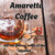Java Junkies Amaretto Coffee. Clear glass of Amaretto with ice sitting on some dried grass and leaves on a brown table.
