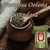 A small wooden spoon filled with dark green loose-leaf oolong rests over a rustic speckled ceramic tea jar on a textured wooden tabletop.