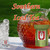 A large hobnail glass pitcher filled with iced tea, ice cubes, and fresh mint leaves sits on a table next to a tall glass filled with ice.