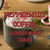Java Junkies Peppermint Coffee.  Dark gray mug full of peppermint coffee topped with whipped cream and peppermint sprinkles.