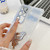 Samsung Galaxy S25 5G Plating Glitter Lens Film Texture Butterfly Holder Wristband Phone Case - White Feathers