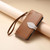 iPhone 17 Leaf Buckle Zipper Wallet Leather Phone Case with Strap - Brown