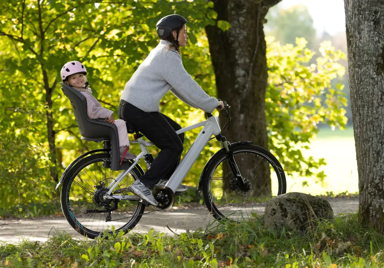 Parent cycling with child in Hamax Amiga frame-mounted bike seat