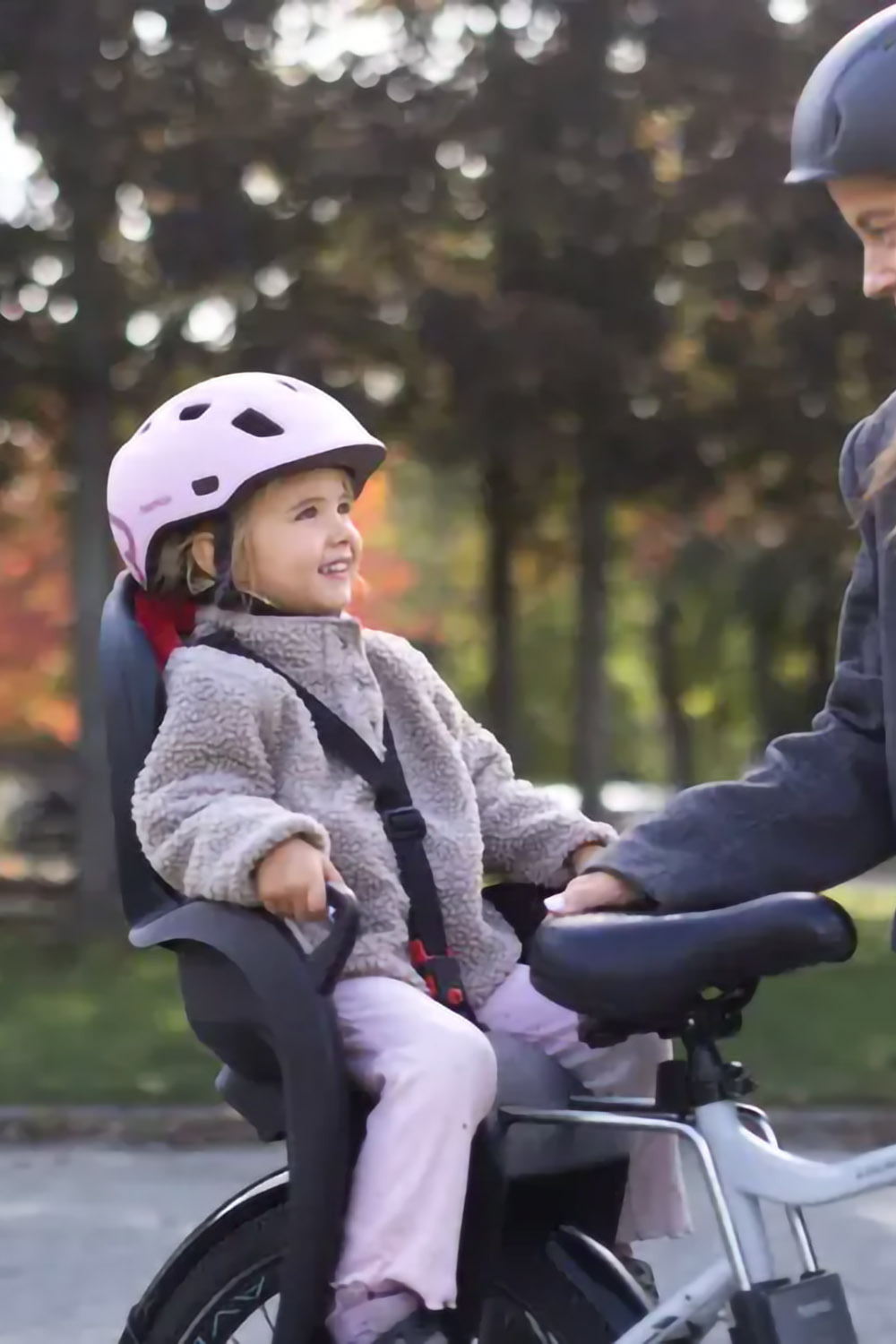 Hamax Kiss frame-mounted bike seat showing dedicated helmet space preventing head from being pushed forward