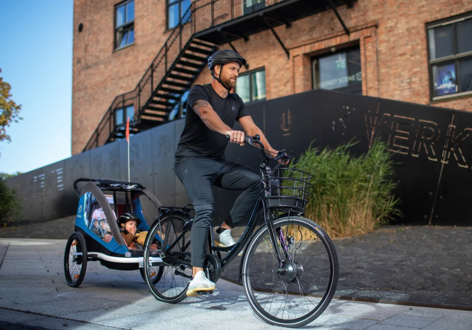 Hamax Traveller 2-seat bike trailer hitched to bicycle with children inside