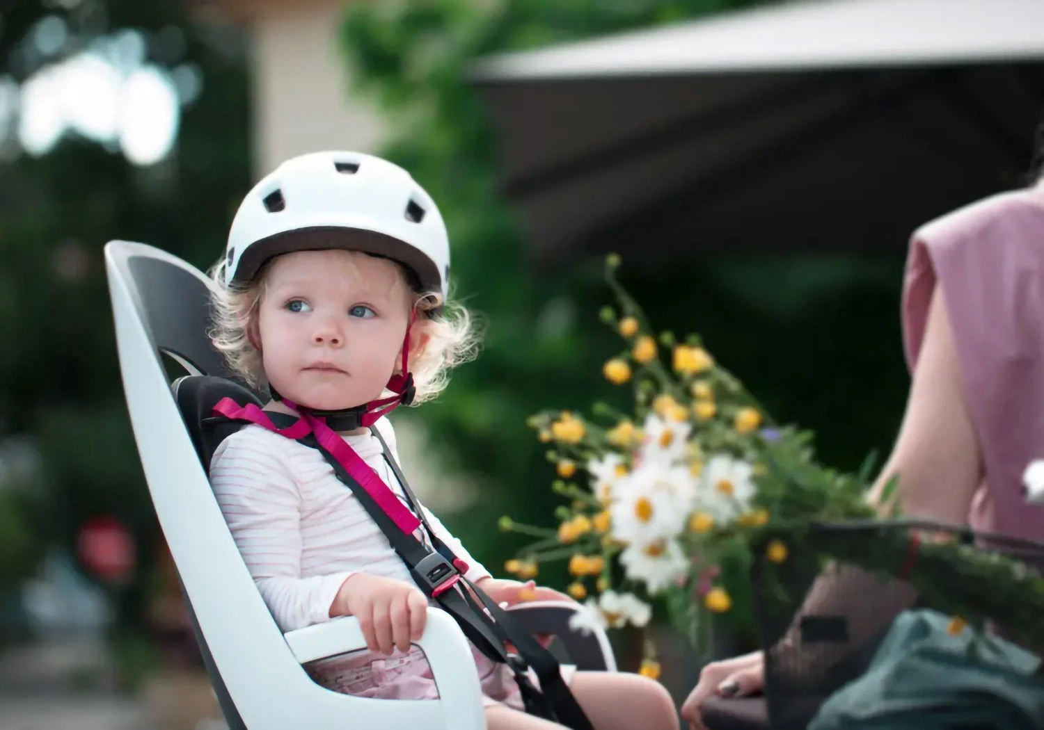 Parent cycling with child seated in Hamax Caress rack-mounted bike seat