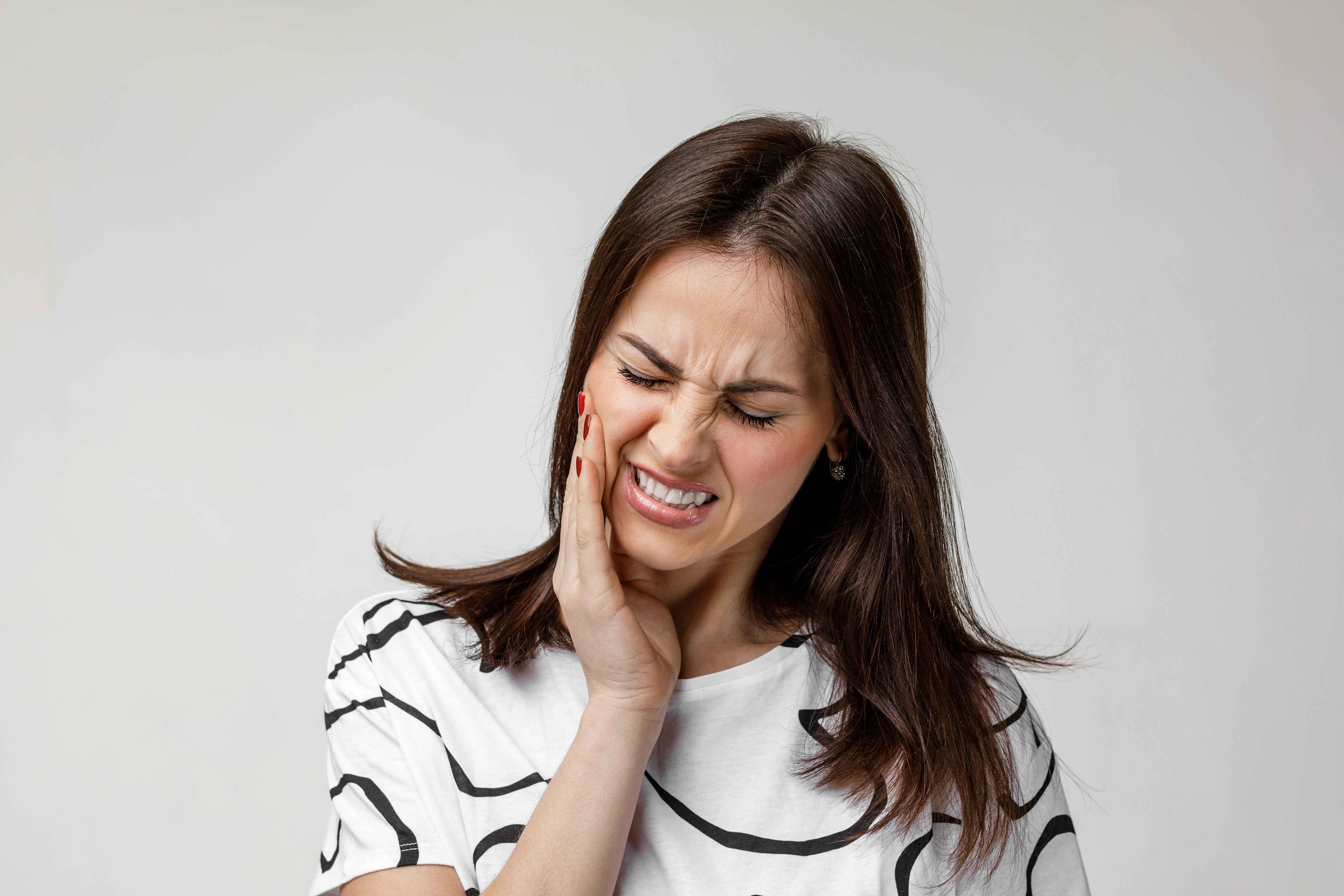 Woman holding the side of her face in pain