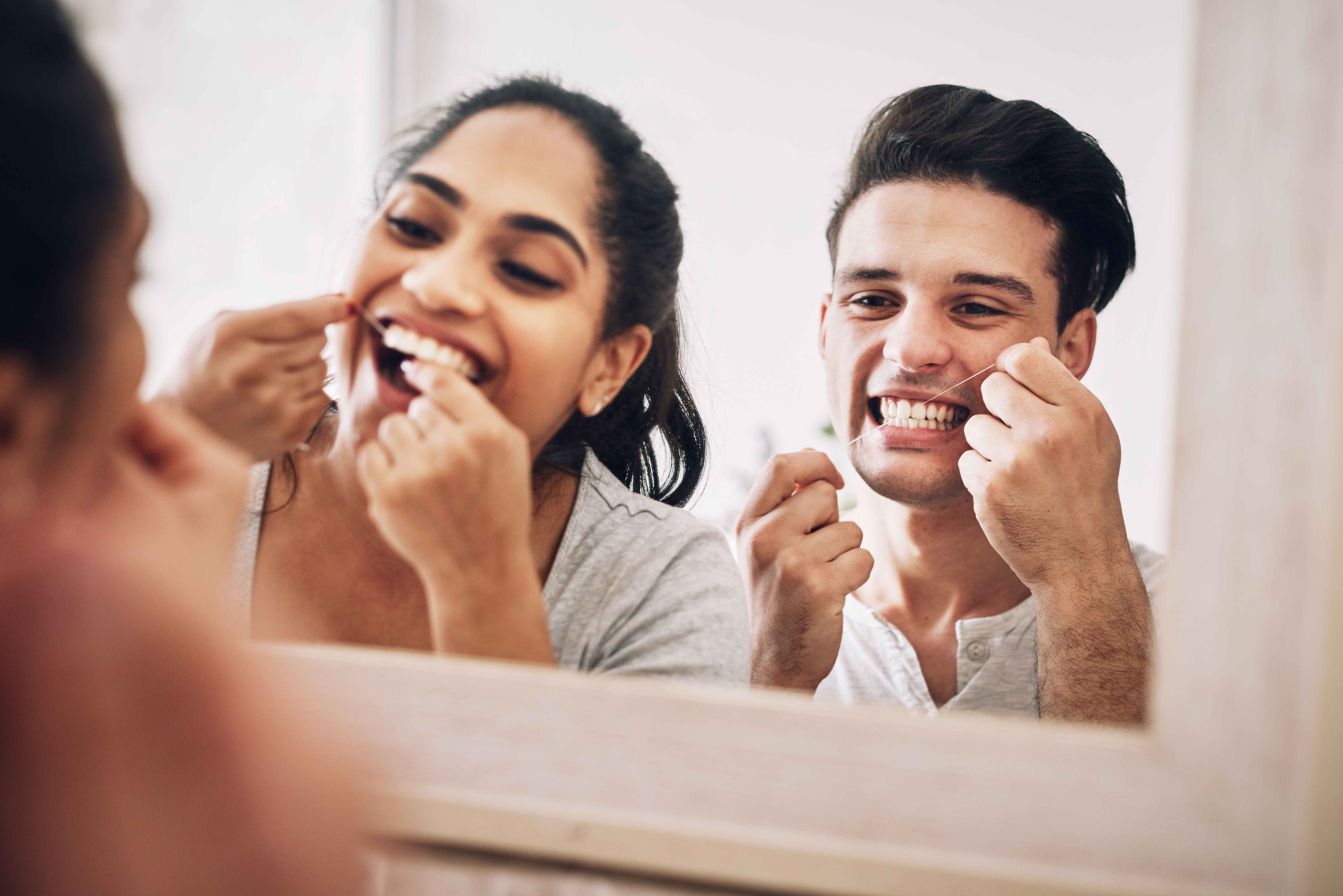 Couple flossing their teeth together