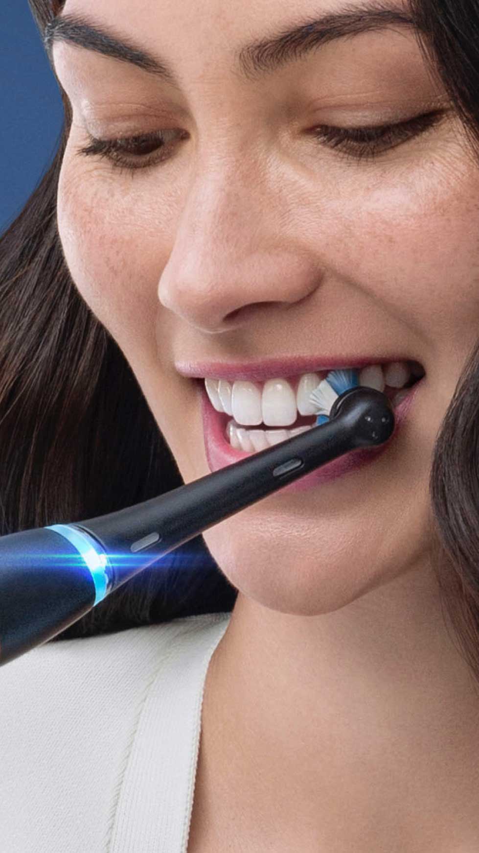 Woman brushing her teeth with an Oral-B Electric Toothbrush as part of her daily oral care routine