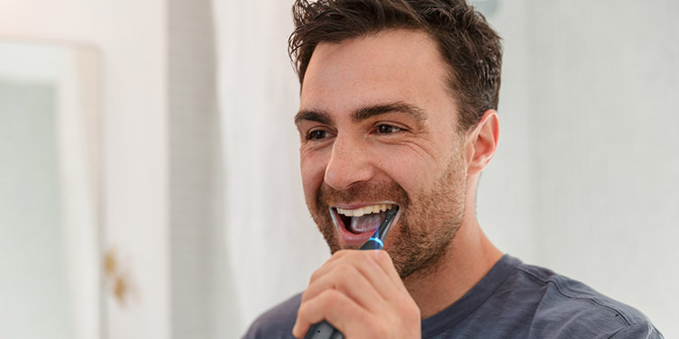 man with electric toothbrush