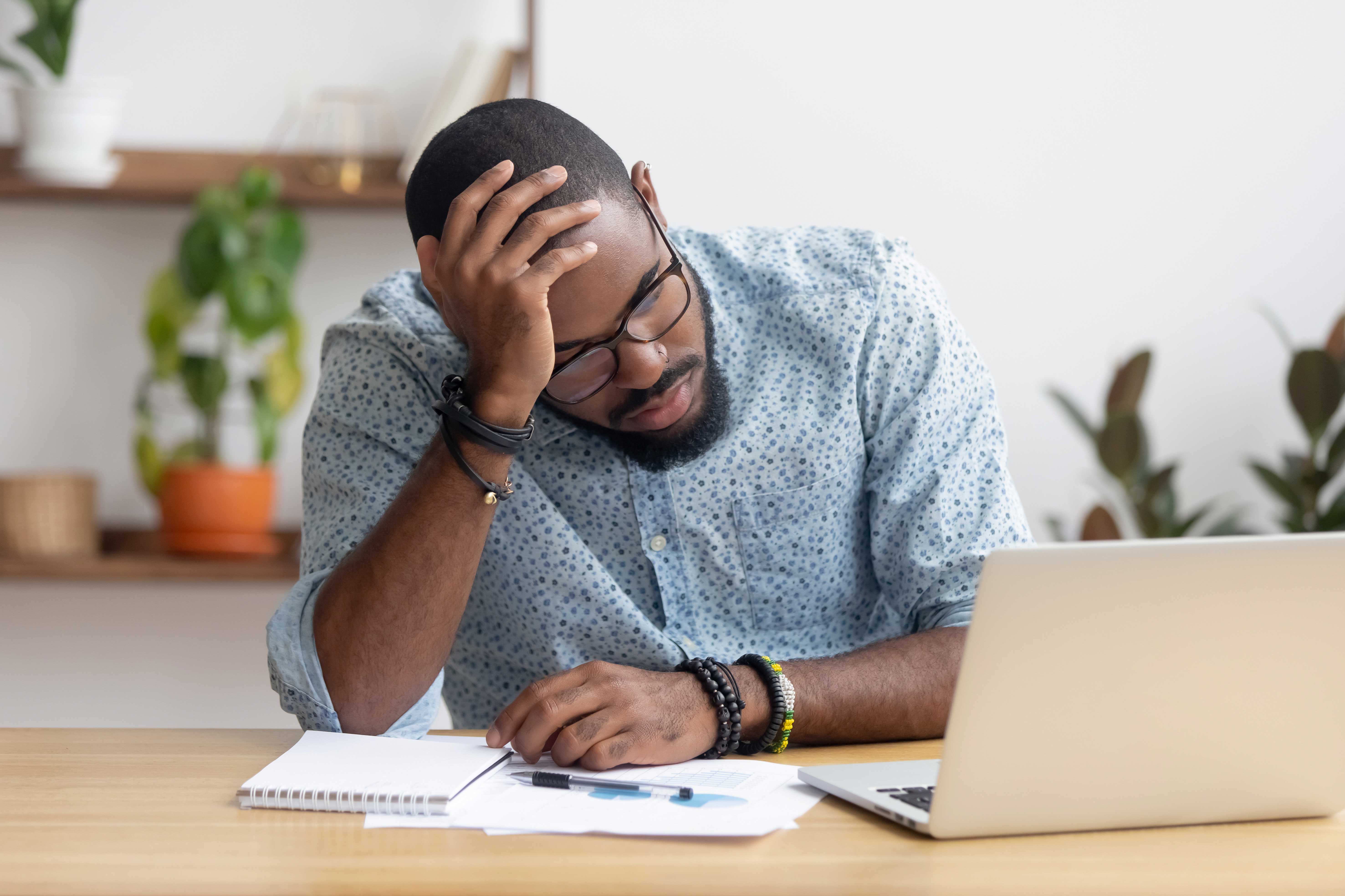 Man at his desk with his head on his hand