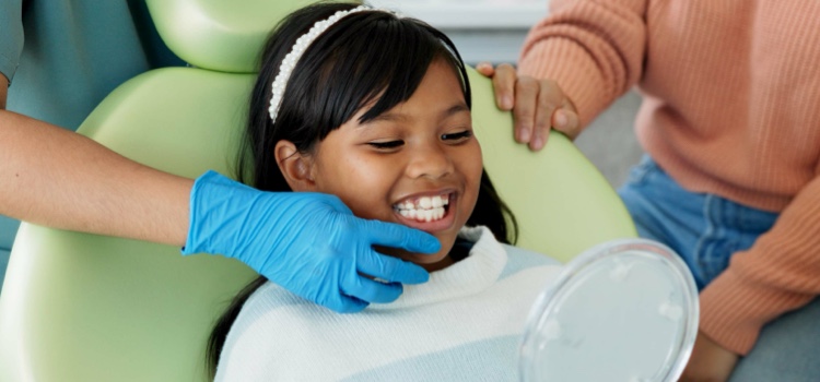 Young child at the dentist looking at their teeth in the mirror