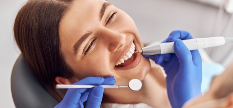 Female dental patient smiling whilst being examined.
