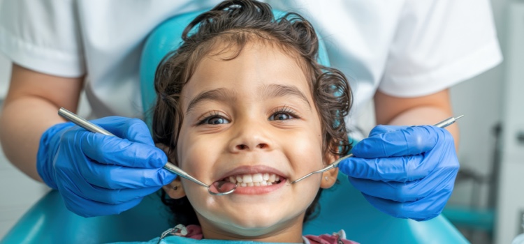 Smiling child at dental check-up with hygienist