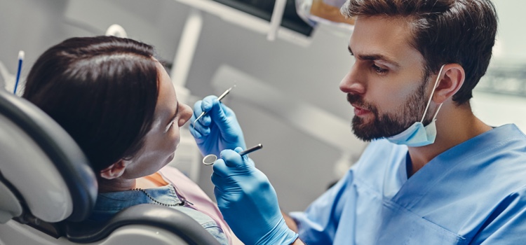 Male dentist examining female patient.