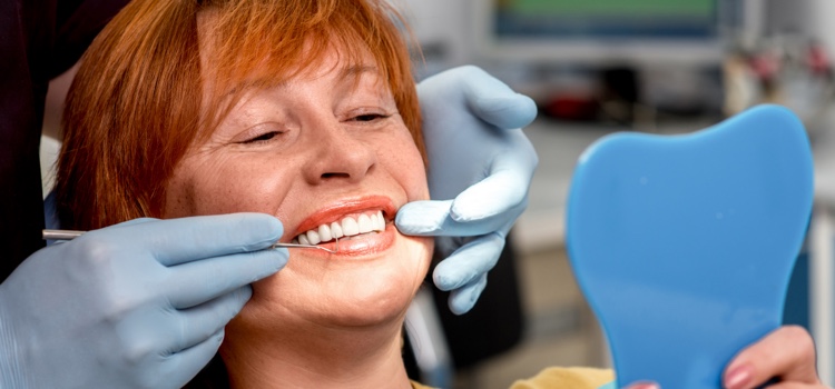 Female dental patient smiling and looking into a mirror