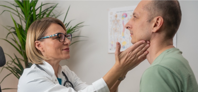Young doctor examining male patient.