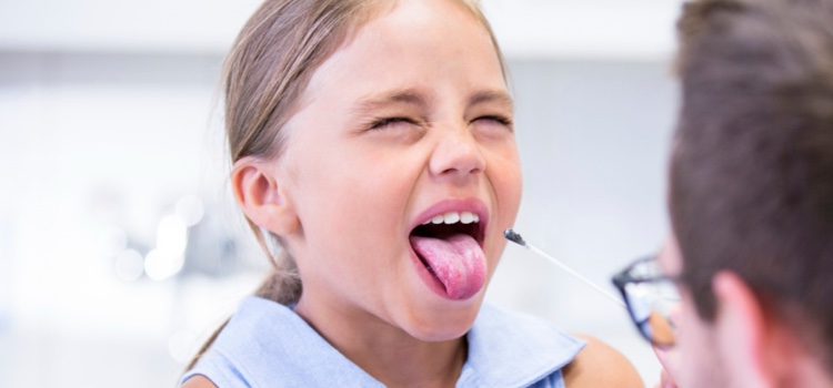 Young girl getting her tongue examined by male dentist