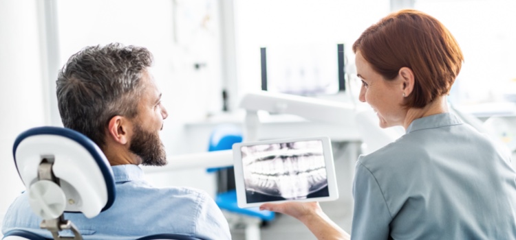 Female dentist explains diagnosis to male patient