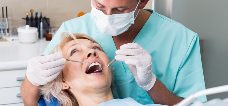 Female patient being examined by male dentist