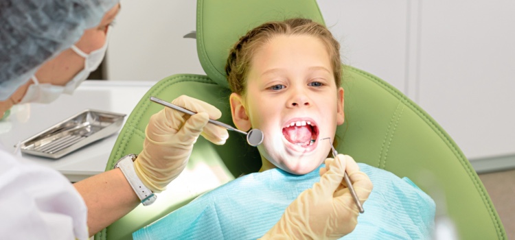 Young girl being examined by female dentist.