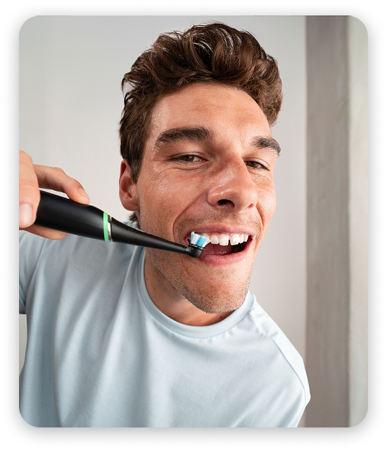 Close‑up of an Oral‑B electric toothbrush in use during a daily brushing routine
