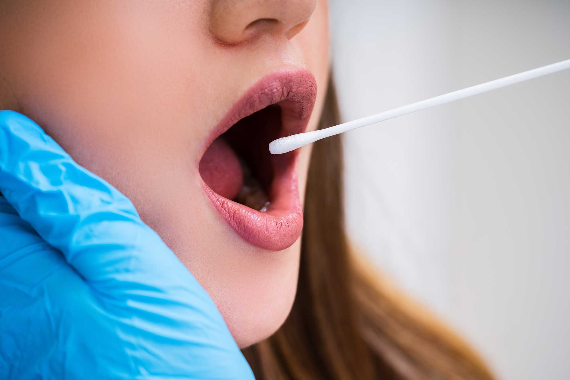 Close up of a woman getting her mouth swabbed