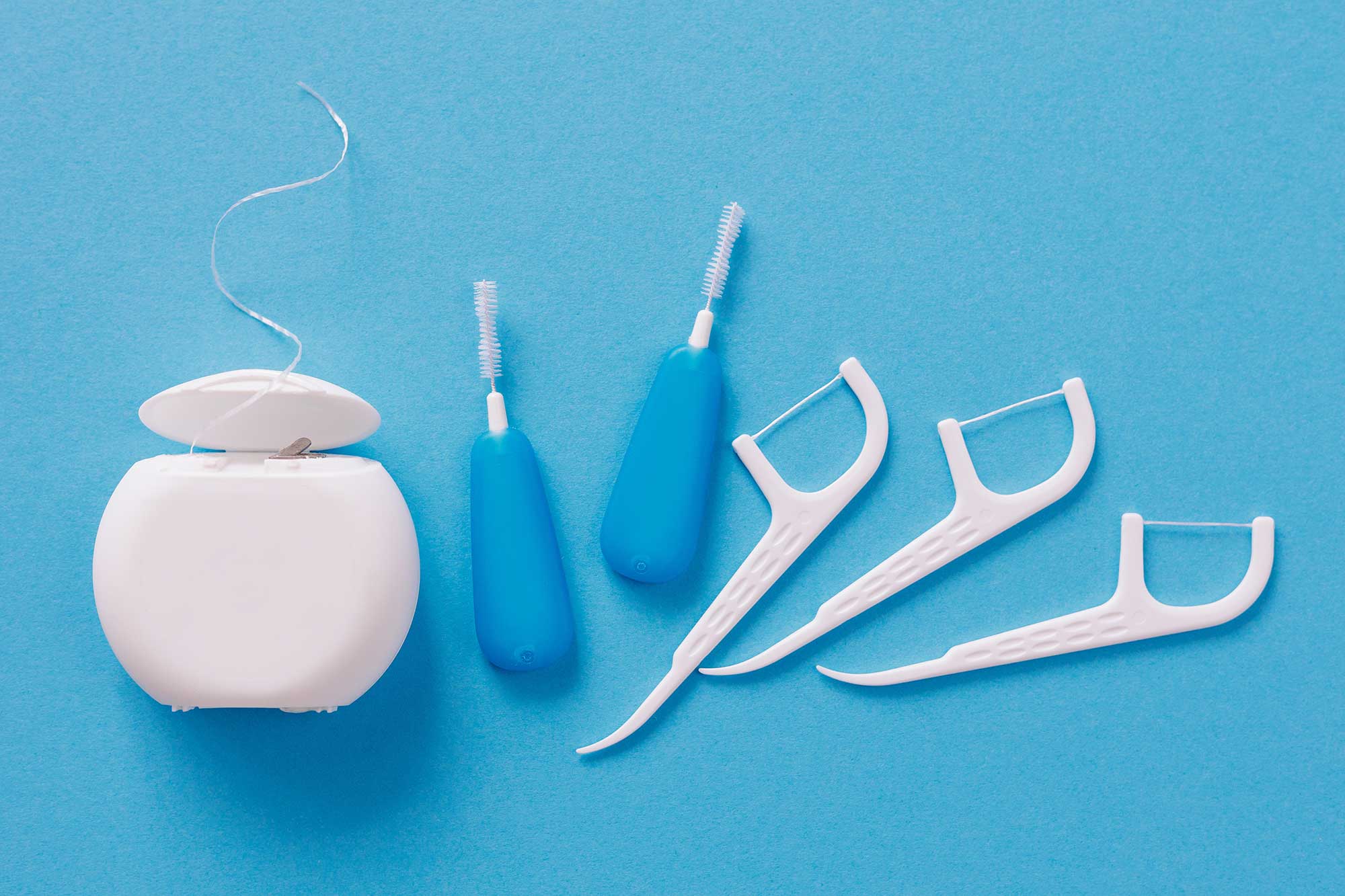 Image of different types of flossers including floss picks and string floss image