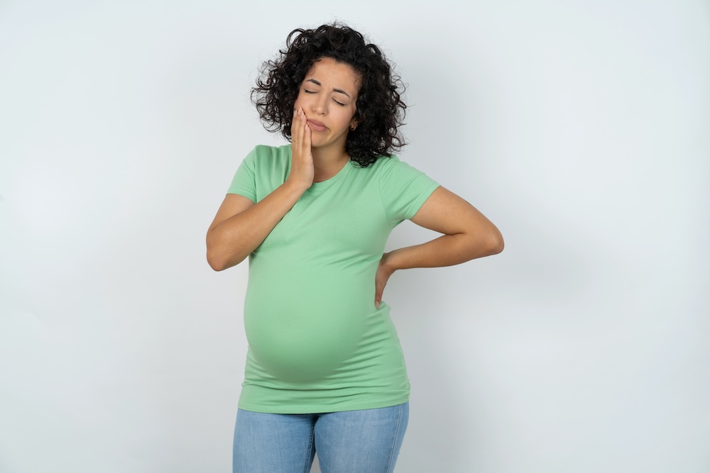 Pregnant woman experiencing pain from gingivitis image