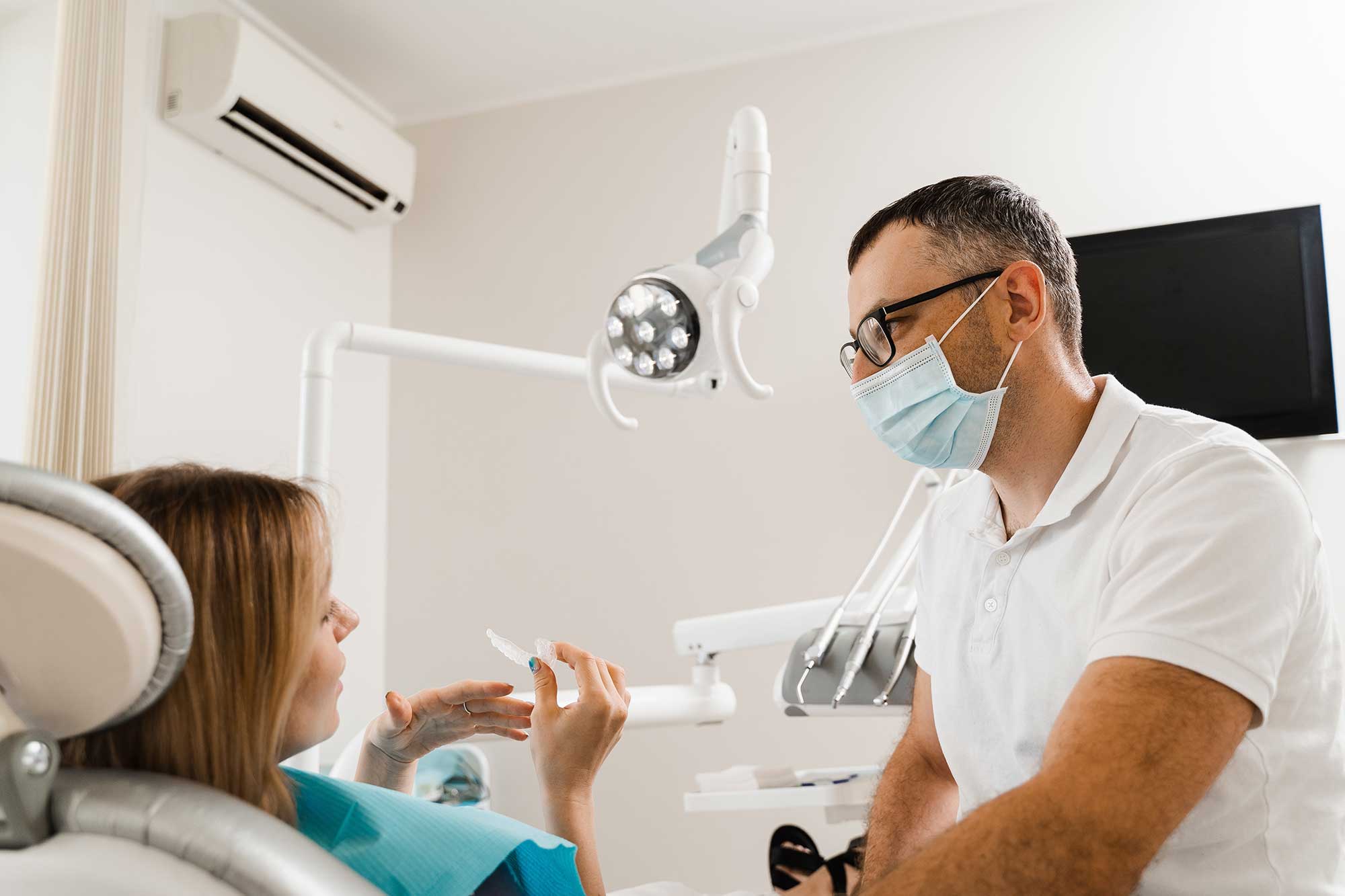 Woman in a dentist’s chair getting a consultation on mouthguards