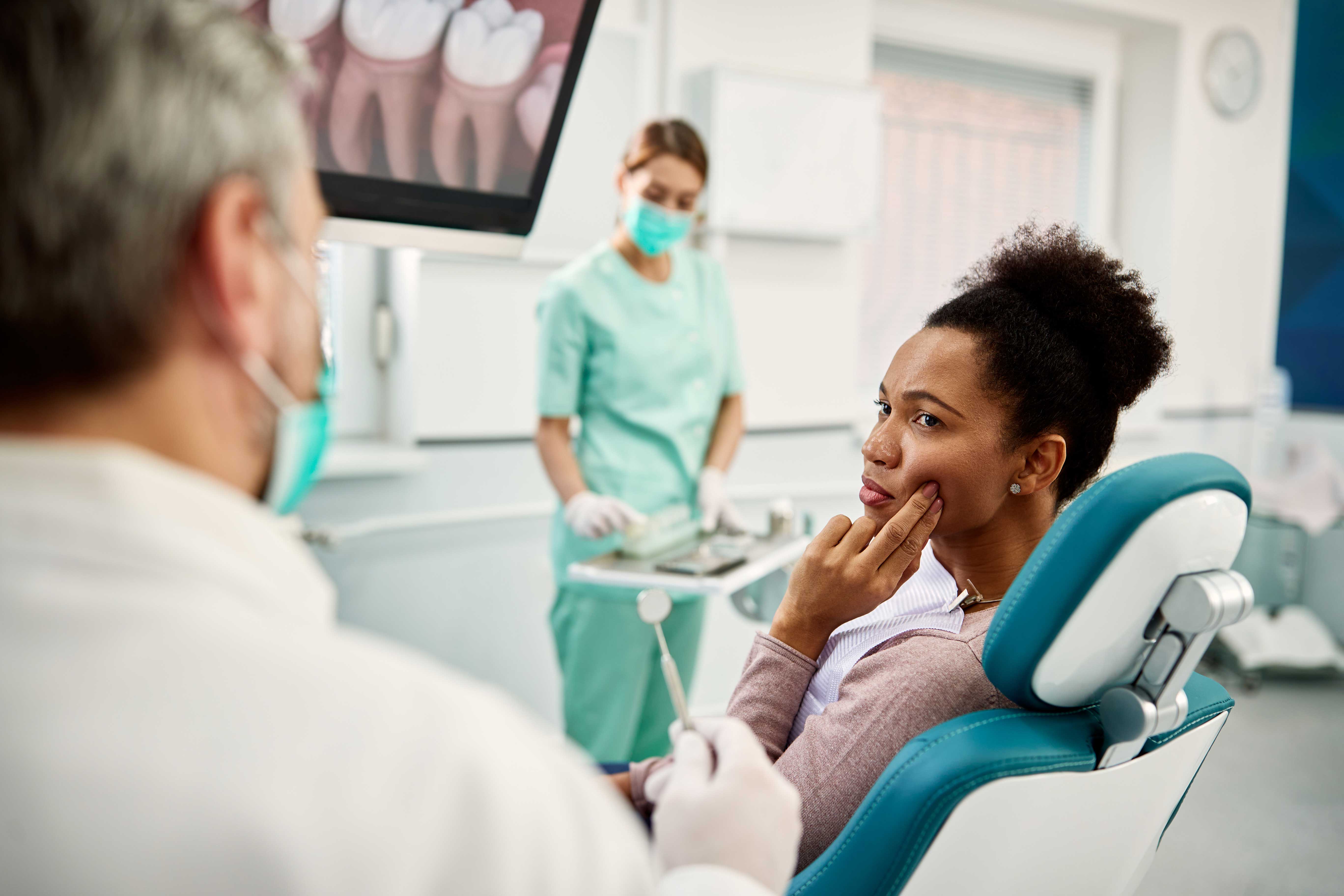 woman-sitting-in-the-exam-chair-at-the-dentists-office