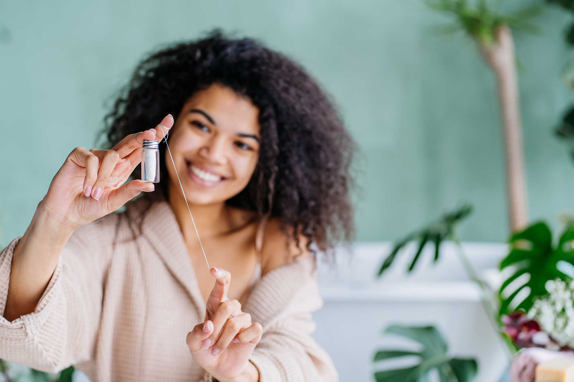 Woman wrapping string floss around her fingers