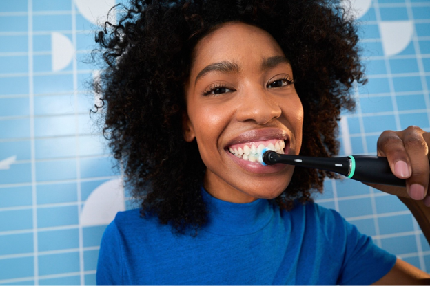 Women smiling brushing her teeth with Oral-B iO electric toothbrush