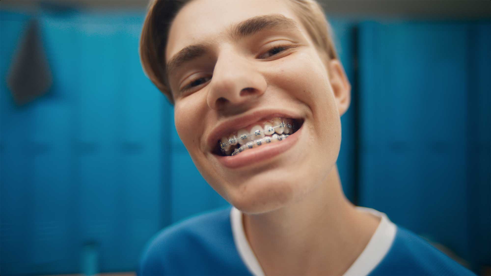 Close-up of teen boy smiling and showing his braces