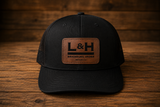 Black mesh-back trucker hat with a genuine leather L&H Branding Irons logo patch.             Do you like this personality?