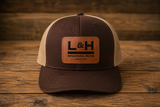 Brown and khaki mesh-back trucker hat with a genuine leather L&H Branding Irons logo patch.