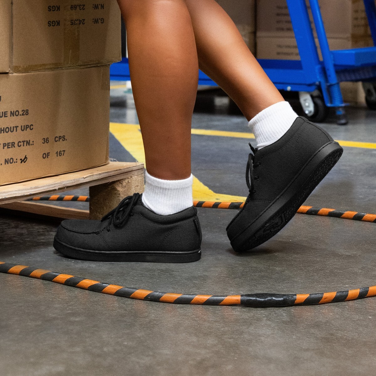 electrical-hazard-square.jpg Warehouse worker wearing women’s electrical hazard shoes, standing near a cable fixed with electrical tape on the ground