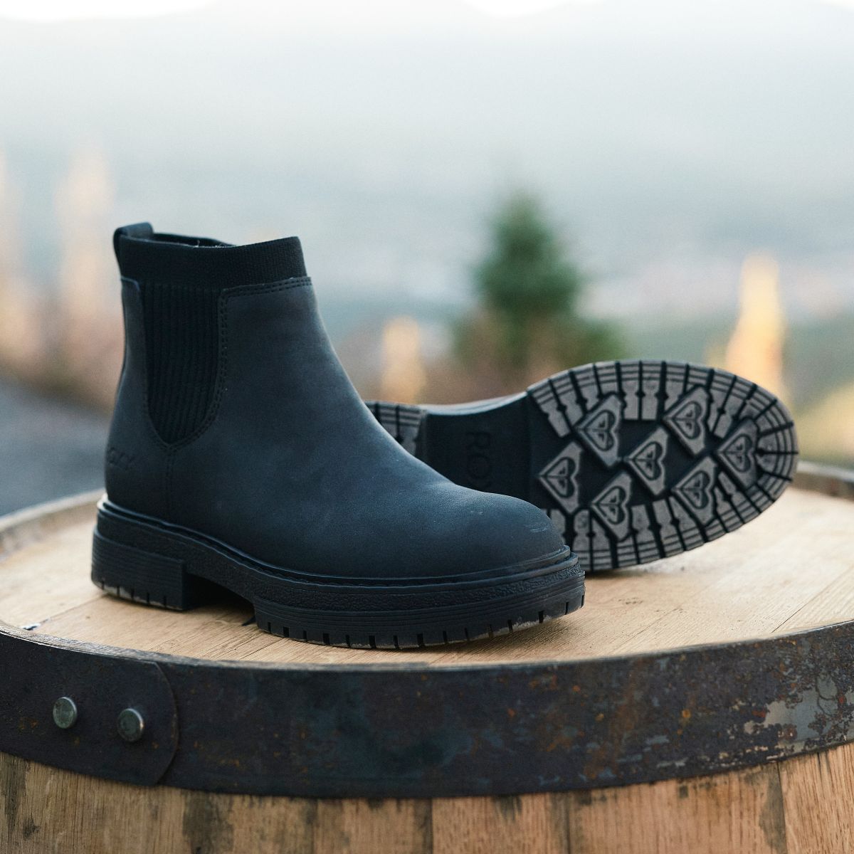 rx90601-jeynawork-roxy-img-79.jpg RX90601 Jeyna Work Boots sitting on a wooden barrel with woods in the background.