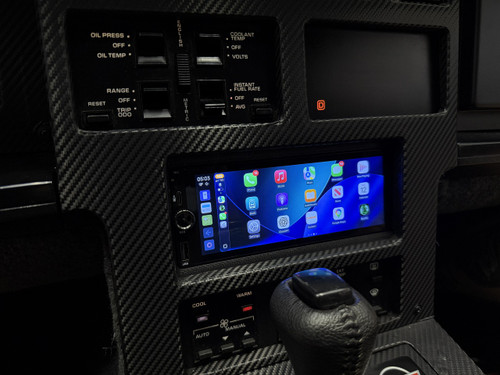 Aftermarket 1.5-DIN touchscreen radio mounted in a custom dash kit for a 1984–1989 Chevrolet Corvette (C4), displaying the Apple CarPlay home screen,