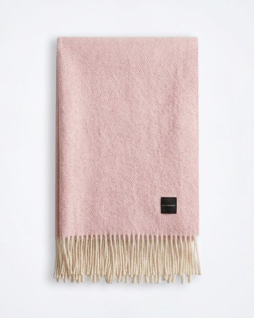 Light pink cotton‑blend throw laid flat against a plain background, showing overall texture and colour.