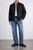 Male model standing front on with one hand in jeans pocket wearing Block 11 navy herringbone quilted chore jacket showing fit and length