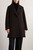Model wearing KAOS women’s dark brown coat styled with knitwear