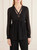Model wearing the Annarita black satin blouse paired with trousers, demonstrating the elegant drape and silhouette.