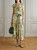 Model wearing the Sandro Ferrone green floral midi dress styled with sandals.