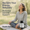 Health Natura BioActive Adrenal Support supplement capsules on a yoga mat with a woman.