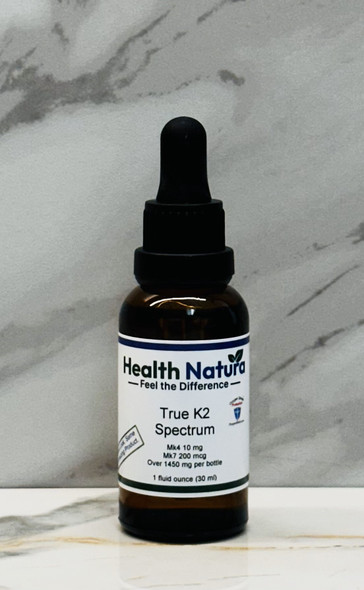 True K2 Spectrum supplement bottle features brand Health Natura on white marble background.