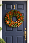 Magnolia Wreath hanging on a navy door.