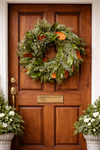 Real fresh green wreath for Christmas hanging on door