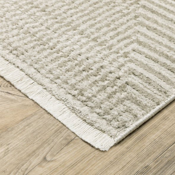 6' X 9' Ivory Beige Taupe And Tan Geometric Power Loom Stain Resistant Area Rug With Fringe